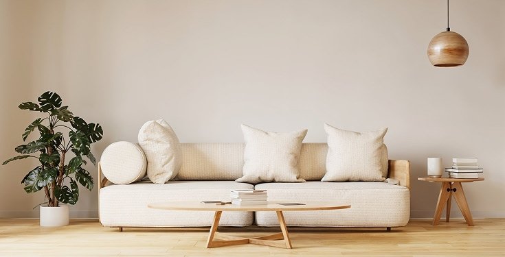 Minimalist living room with a cream sofa, oval oak coffee table and a copper pendant lamp